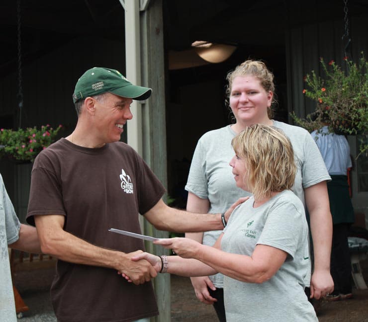 Farm Funding representative hands a community organization a $1,000 check