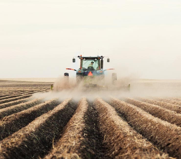 Tractor tilling a New England field